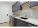 Laundry room featuring gray cabinets, a tile backsplash and new appliances at 3202 E Orange Dr, Phoenix, AZ 85018