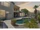 Inviting backyard pool with lush tropical landscaping, covered patio, and elegant stonework, perfect for outdoor enjoyment at 3202 E Orange Dr, Phoenix, AZ 85018