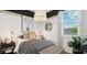 Charming bedroom with a patterned bedspread, unique lighting fixture, and serene window view at 35556 N Common Ct, San Tan Valley, AZ 85140