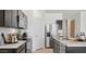 Galley style kitchen boasts stainless steel appliances, dark cabinets, and stone countertops at 35556 N Common Ct, San Tan Valley, AZ 85140
