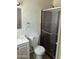 Bathroom featuring a single sink vanity, toilet, and a shower with glass doors at 3608 W Hazelwood St, Phoenix, AZ 85019