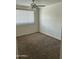 Cozy bedroom with carpet flooring, a ceiling fan, and large window at 3608 W Hazelwood St, Phoenix, AZ 85019