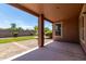 Relaxing back porch offers a shaded area with landscaped backyard and privacy wall at 40275 W Art Pl, Maricopa, AZ 85138