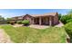 Exterior view of the home showcasing a well-manicured backyard with patio area at 40275 W Art Pl, Maricopa, AZ 85138