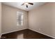 Bedroom with a ceiling fan and window offering natural light, complemented by wood-look flooring at 40275 W Art Pl, Maricopa, AZ 85138