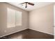 Bedroom with wood-look floors, a ceiling fan, and a window for natural light and ventilation at 40275 W Art Pl, Maricopa, AZ 85138