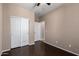 Bedroom featuring a ceiling fan, wood-look flooring, and a closet with sliding doors for extra storage at 40275 W Art Pl, Maricopa, AZ 85138