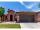 Charming single-story home with a well-maintained front yard, arched entry, and a two car garage at 40275 W Art Pl, Maricopa, AZ 85138
