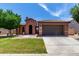 Charming single-story home with a well-maintained front yard, arched entry, and a two car garage at 40275 W Art Pl, Maricopa, AZ 85138