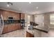 A kitchen featuring built-in oven and microwave, granite countertops, a mosaic backsplash, and dark wood cabinets at 40275 W Art Pl, Maricopa, AZ 85138