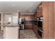 A kitchen featuring a stainless steel refrigerator, dark wood cabinets, granite countertops, and double ovens at 40275 W Art Pl, Maricopa, AZ 85138