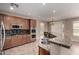 This kitchen has dark wood cabinets, stainless steel appliances, a granite countertop, and a mosaic tile backsplash at 40275 W Art Pl, Maricopa, AZ 85138