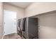 Convenient laundry room equipped with modern washer and dryer, with access door to the outside at 40275 W Art Pl, Maricopa, AZ 85138