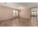 Spacious living room featuring tile floors, a large window and stylish chandelier at 40275 W Art Pl, Maricopa, AZ 85138