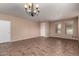 Spacious living room featuring tile floors, a large window and a entry door at 40275 W Art Pl, Maricopa, AZ 85138