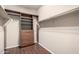 Spacious walk-in closet with custom built-in shelving and drawers, with wood-look flooring at 40275 W Art Pl, Maricopa, AZ 85138