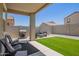 Inviting backyard with an outdoor kitchen, artificial grass, and stylish patio furniture at 40441 W Hillman Dr, Maricopa, AZ 85138