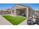 Expansive backyard featuring artificial grass, patio furniture, and a built-in grill at 40441 W Hillman Dr, Maricopa, AZ 85138