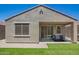 Charming covered patio with green lawn and stylish seating invites relaxation and outdoor enjoyment at 40441 W Hillman Dr, Maricopa, AZ 85138
