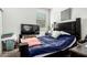 Cozy bedroom with dark wood furnishings and a large TV for relaxation at 40441 W Hillman Dr, Maricopa, AZ 85138
