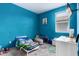 Vibrant bedroom with bright blue walls, carpeted floors, and a window at 40441 W Hillman Dr, Maricopa, AZ 85138