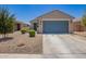 Charming single-story home with a blue garage door and low-maintenance desert landscaping at 40441 W Hillman Dr, Maricopa, AZ 85138