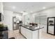 Open kitchen features white cabinets, granite countertops, stainless steel appliances and a large island at 40441 W Hillman Dr, Maricopa, AZ 85138