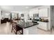 Open kitchen features white cabinets, granite countertops, stainless steel appliances and view to dining and living areas at 40441 W Hillman Dr, Maricopa, AZ 85138