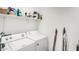Functional laundry room with a white washer and dryer, and storage shelving at 40441 W Hillman Dr, Maricopa, AZ 85138