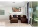 Spacious living room featuring tile flooring, sectional couch, and slider to the backyard at 40441 W Hillman Dr, Maricopa, AZ 85138