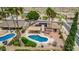 Aerial view of a desert home with a pool, covered patio, solar panels, and palm trees, fully fenced for privacy at 4229 E Pearce Rd, Phoenix, AZ 85044