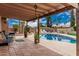Back patio with tile flooring, a pool, plants, trees and outdoor decor at 4229 E Pearce Rd, Phoenix, AZ 85044
