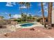 Backyard oasis with a kidney-shaped pool, lounge chairs, desert landscaping, and a view of distant mountains at 4229 E Pearce Rd, Phoenix, AZ 85044