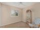 Bedroom with a large window, ceiling fan, chair and cabinet with glass shelving at 4229 E Pearce Rd, Phoenix, AZ 85044