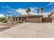 Home featuring a wide driveway, two car garage, neutral stucco, and low maintenance desert landscaping at 4229 E Pearce Rd, Phoenix, AZ 85044
