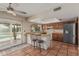 An open kitchen with a breakfast bar features warm wood cabinetry, terracotta floors, and a view of the outdoor pool at 4229 E Pearce Rd, Phoenix, AZ 85044