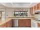 The kitchen features wood cabinets, stainless steel dishwasher, and a bright window overlooking the well-manicured backyard at 4229 E Pearce Rd, Phoenix, AZ 85044