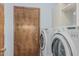 Laundry room with a wood door, shelving, a washer and a dryer at 4229 E Pearce Rd, Phoenix, AZ 85044