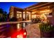 Backyard features a heated pool, a patio dining set, a bar with a grill, and cozy outdoor lighting at 42293 W Good Vibrations Ln, Maricopa, AZ 85138