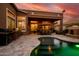 A cozy backyard featuring a covered patio, outdoor dining area, fireplace, and a refreshing pool at 42293 W Good Vibrations Ln, Maricopa, AZ 85138