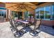Outdoor dining area with a large table, chairs, and umbrella for shaded seating and relaxation at 42293 W Good Vibrations Ln, Maricopa, AZ 85138
