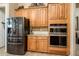 Well-equipped kitchen with stainless steel appliances and stylish wood cabinets at 42293 W Good Vibrations Ln, Maricopa, AZ 85138