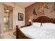 Main bedroom with detailed bed frame, and decorated with western art at 42293 W Good Vibrations Ln, Maricopa, AZ 85138