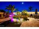 A tranquil backyard showcasing a lovely pool with waterfall features, set amongst mature palm trees at 42293 W Good Vibrations Ln, Maricopa, AZ 85138