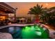 Relaxing backyard oasis features a pristine pool with waterfalls, palm trees, and an outdoor fireplace at 42293 W Good Vibrations Ln, Maricopa, AZ 85138