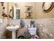 Powder room with patterned tile, decorative accents, and pedestal sink at 42293 W Good Vibrations Ln, Maricopa, AZ 85138