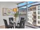 Modern dining area next to a large window, featuring a glass table and stylish chairs with a modern art piece at 4747 N Scottsdale Rd # 4003, Scottsdale, AZ 85251