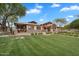 Beautiful clubhouse exterior with stone accents, covered porches, and manicured lawn at 4756 E Ironhorse Rd, Gilbert, AZ 85297