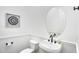 Stylish powder room features a sleek oval mirror, modern fixtures, and a decorative art piece at 4756 E Ironhorse Rd, Gilbert, AZ 85297
