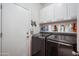 Well-equipped laundry room with front loading washer/dryer and ample cabinet space for storage at 4819 E Villa Theresa Dr, Scottsdale, AZ 85254